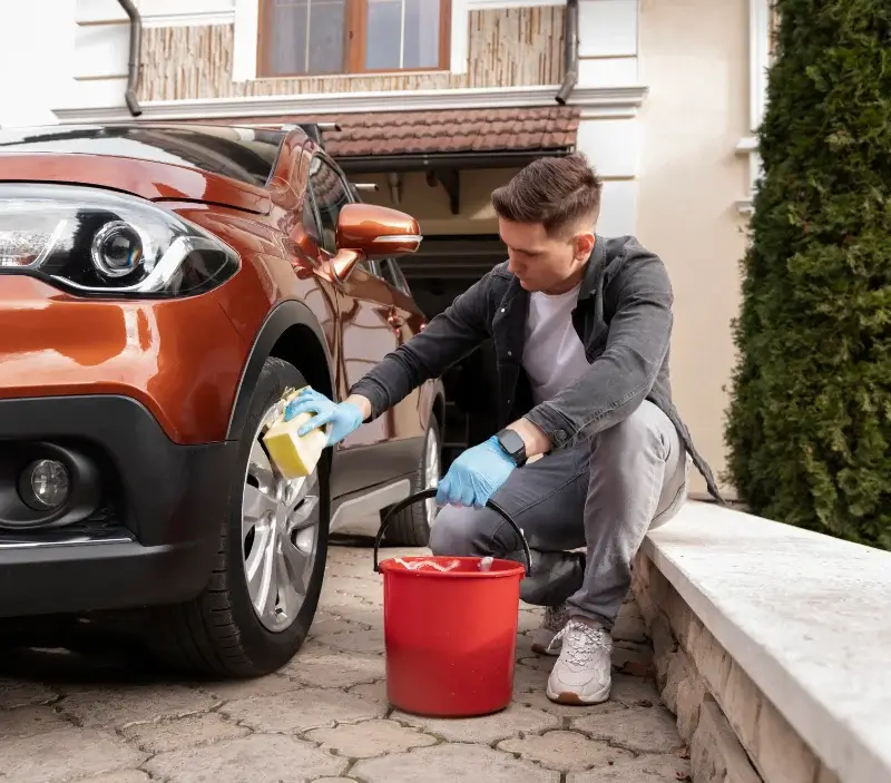 Lavage auto à domicile Romagny-sous-Rougemont : professionnel intervenant sur un véhicule